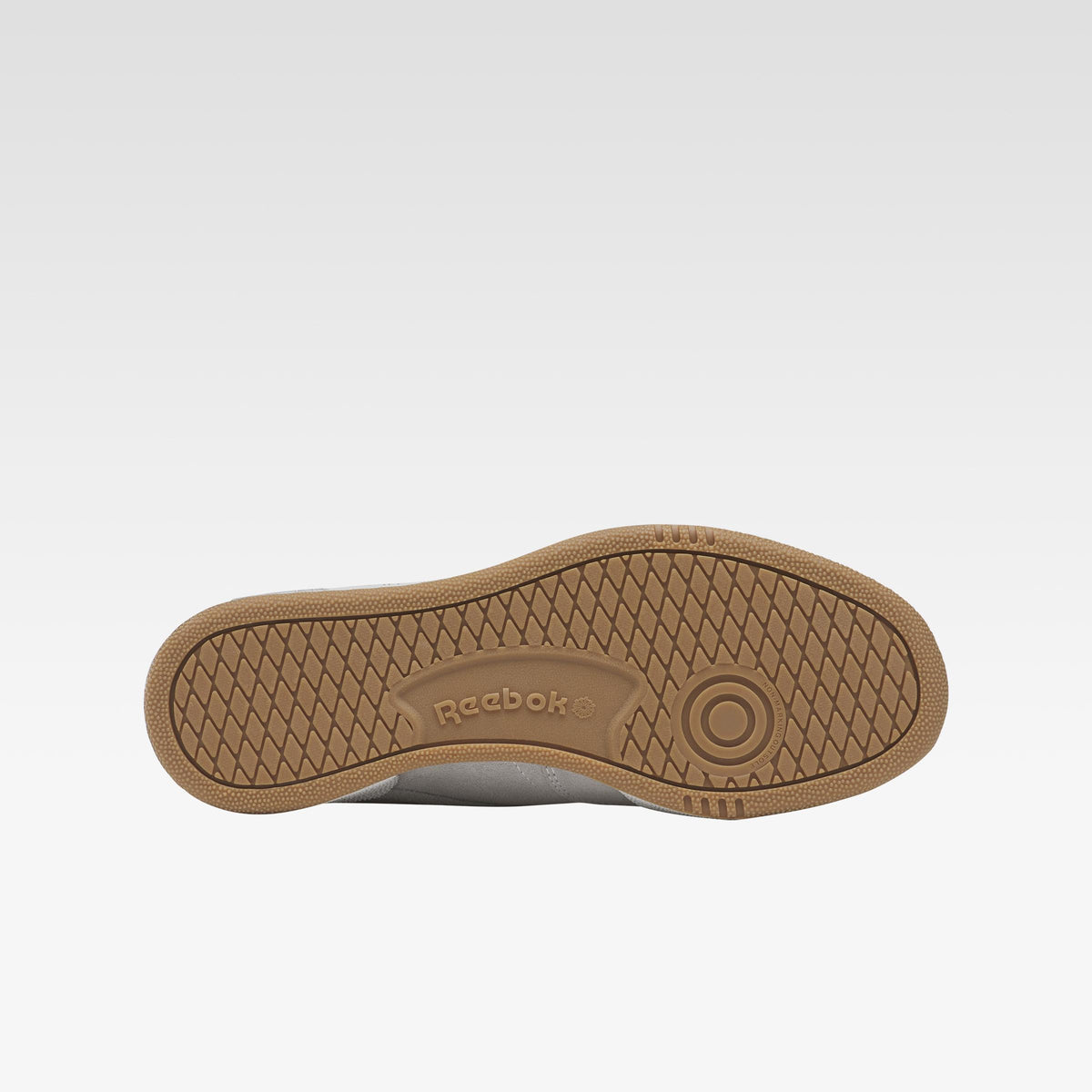 Brown rubber shoe sole with "Reebok" text and a circular pattern.
