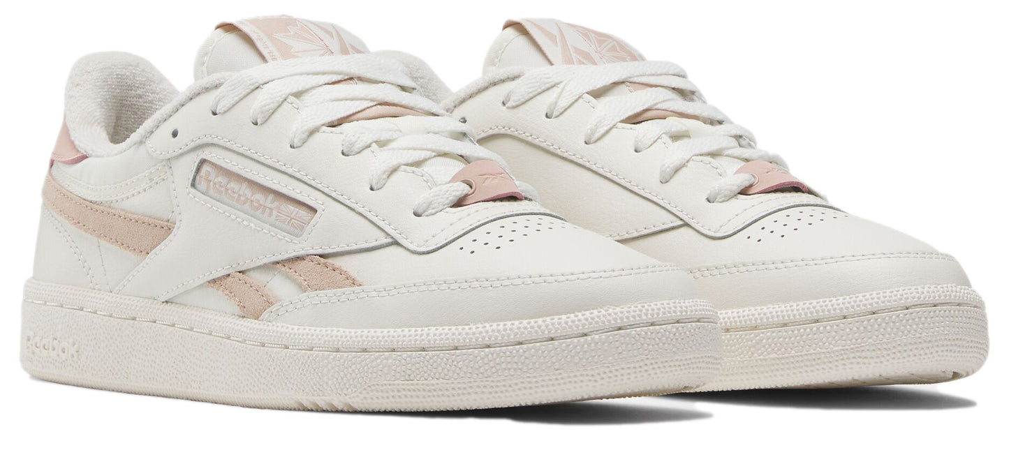 A pair of low-top sneakers, primarily off-white with light pink accents.