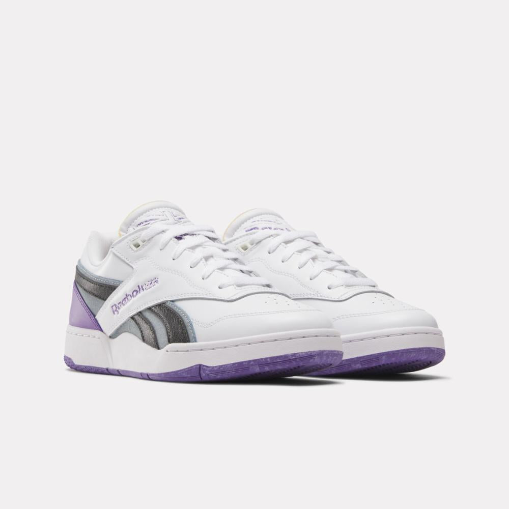 A pair of low-top sneakers with white uppers, gray stripes, and purple heel and sole accents.