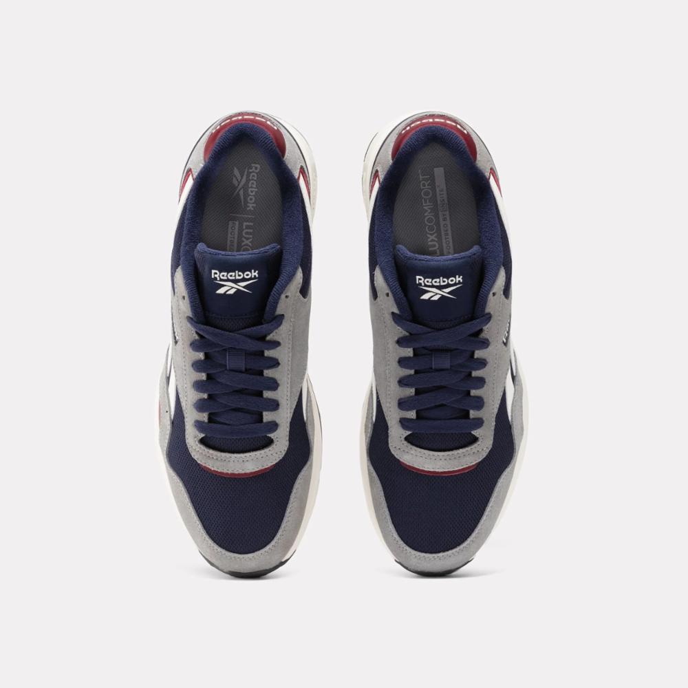 Pair of running shoes, top view. Shoes have dark blue toe, gray vamp, dark blue laces, and dark red inside.