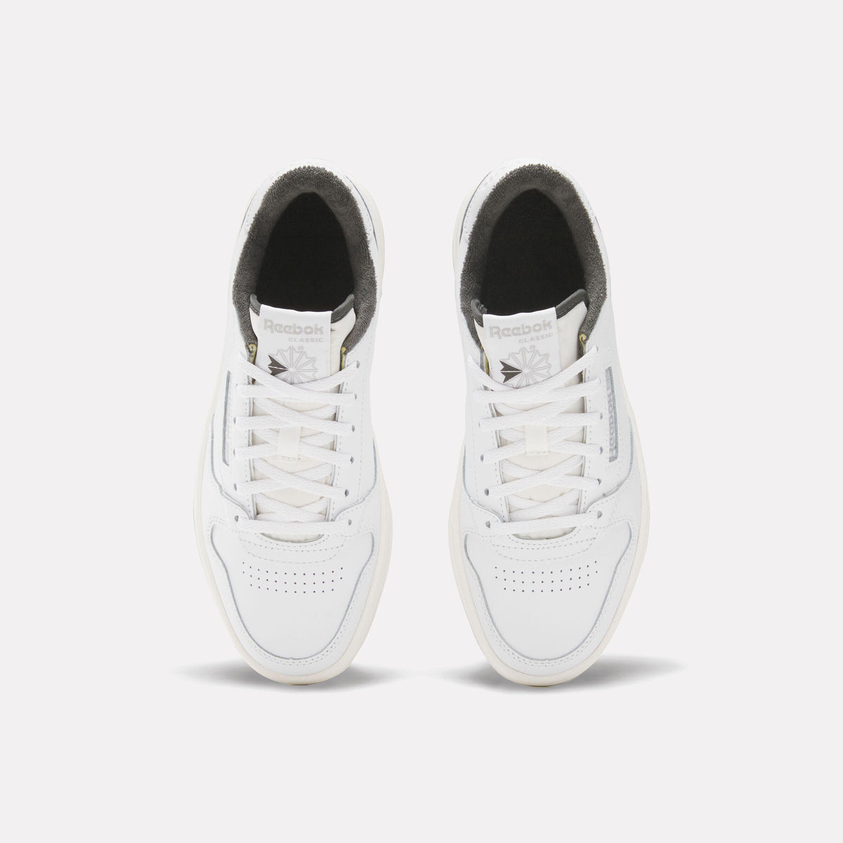 Two white Reebok sneakers, top view.