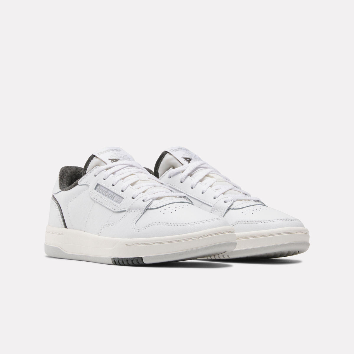 Pair of white low-top sneakers with lace-up closure.