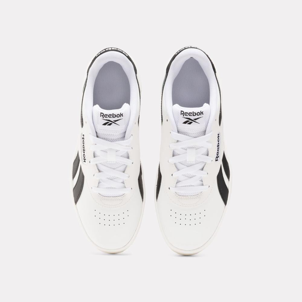 Top-down view of two white shoes with black trim and white laces; "Reebok" printed on side and on tongue.