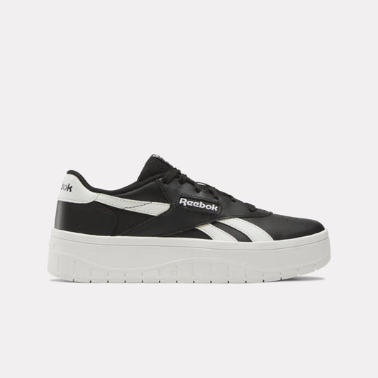 Black and white platform sneaker with visible "Reebok" text.