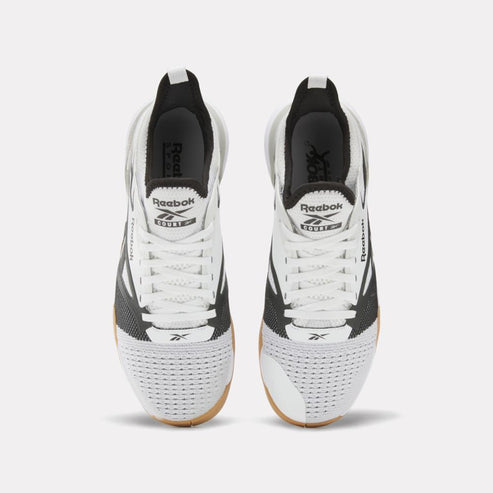 Pair of athletic shoes, white with black accents, lace-up.