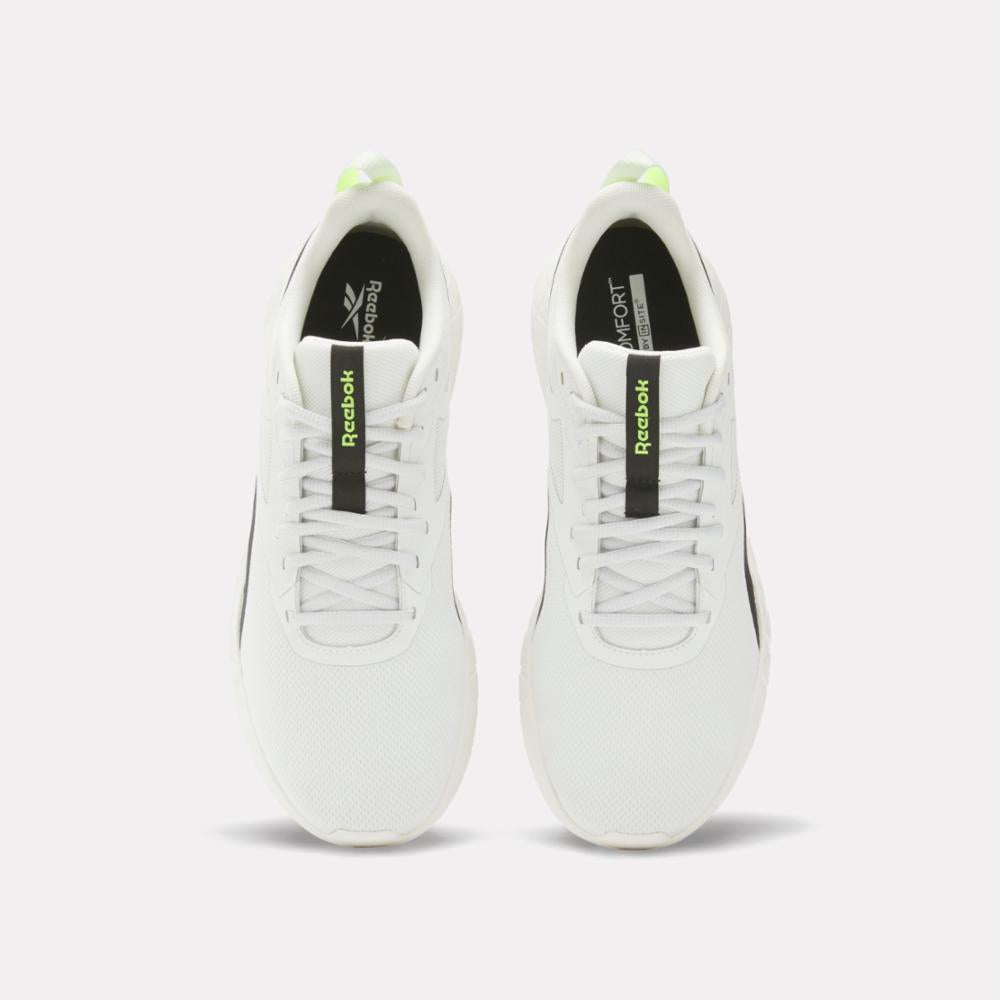 A pair of white athletic shoes with black and lime green accents and white laces.