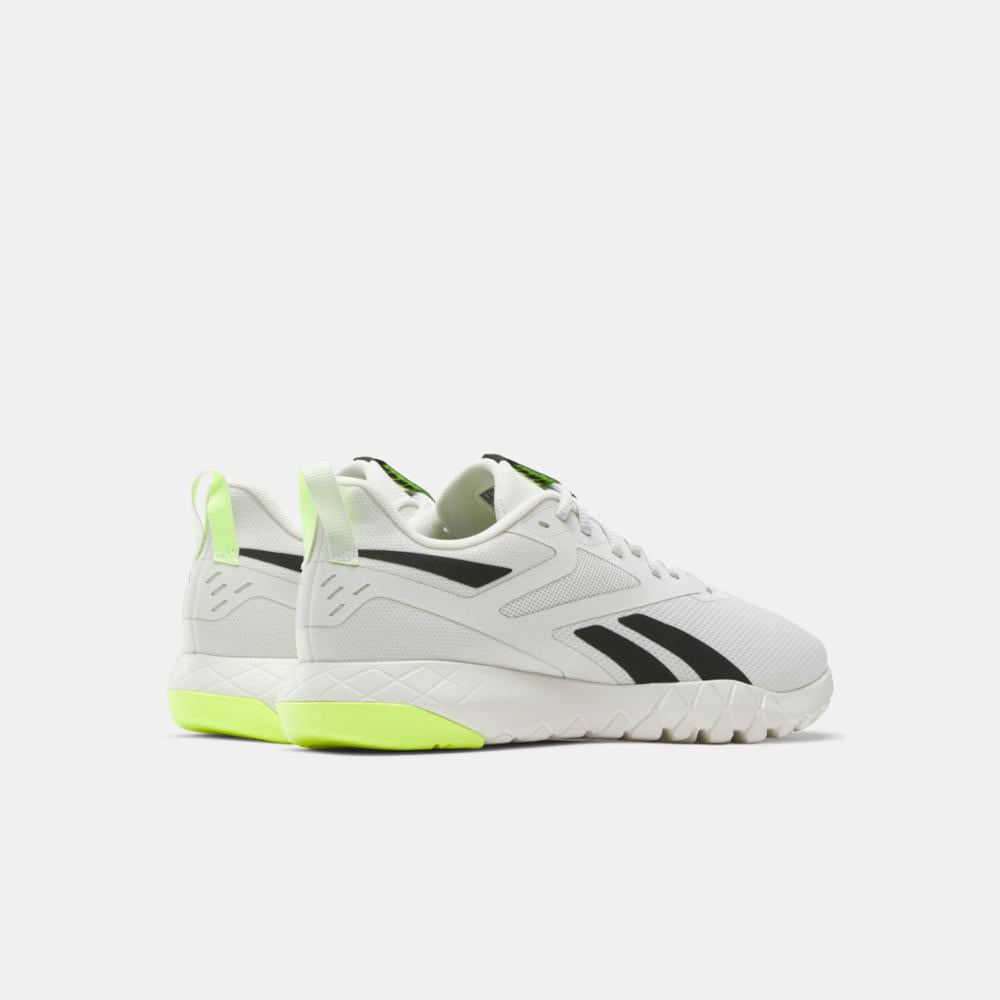White athletic shoe with black stripes and neon green accent.