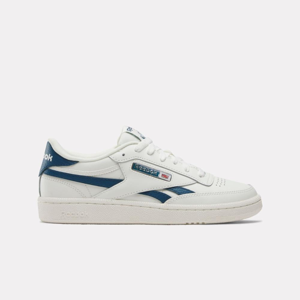 Side view of a white sneaker with navy stripe and heel.