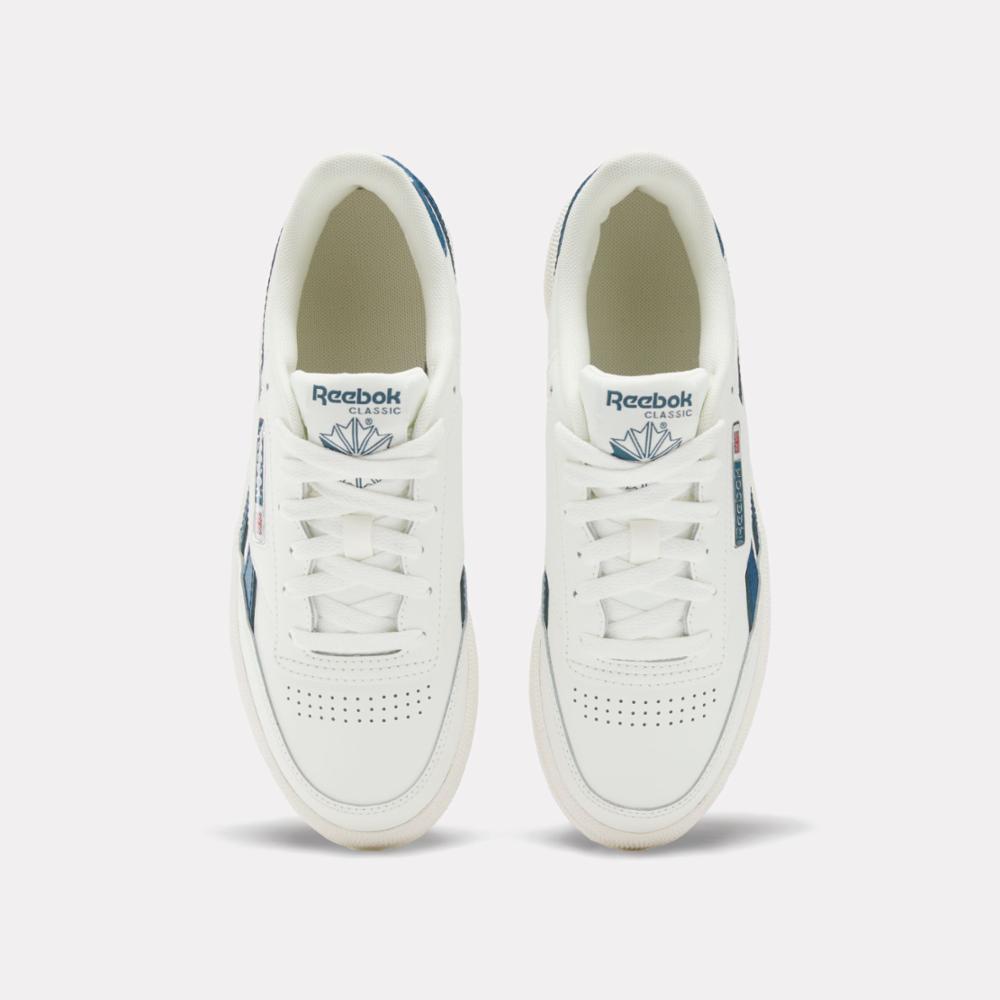 A pair of white sneakers with "Reebok Classic" and the Reebok logo on the tongue.