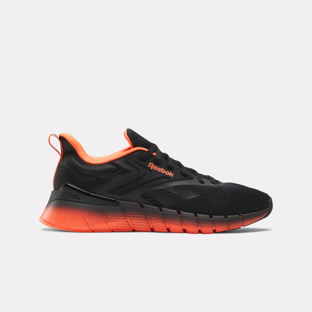 Black athletic shoe with orange accents, showing the side view.