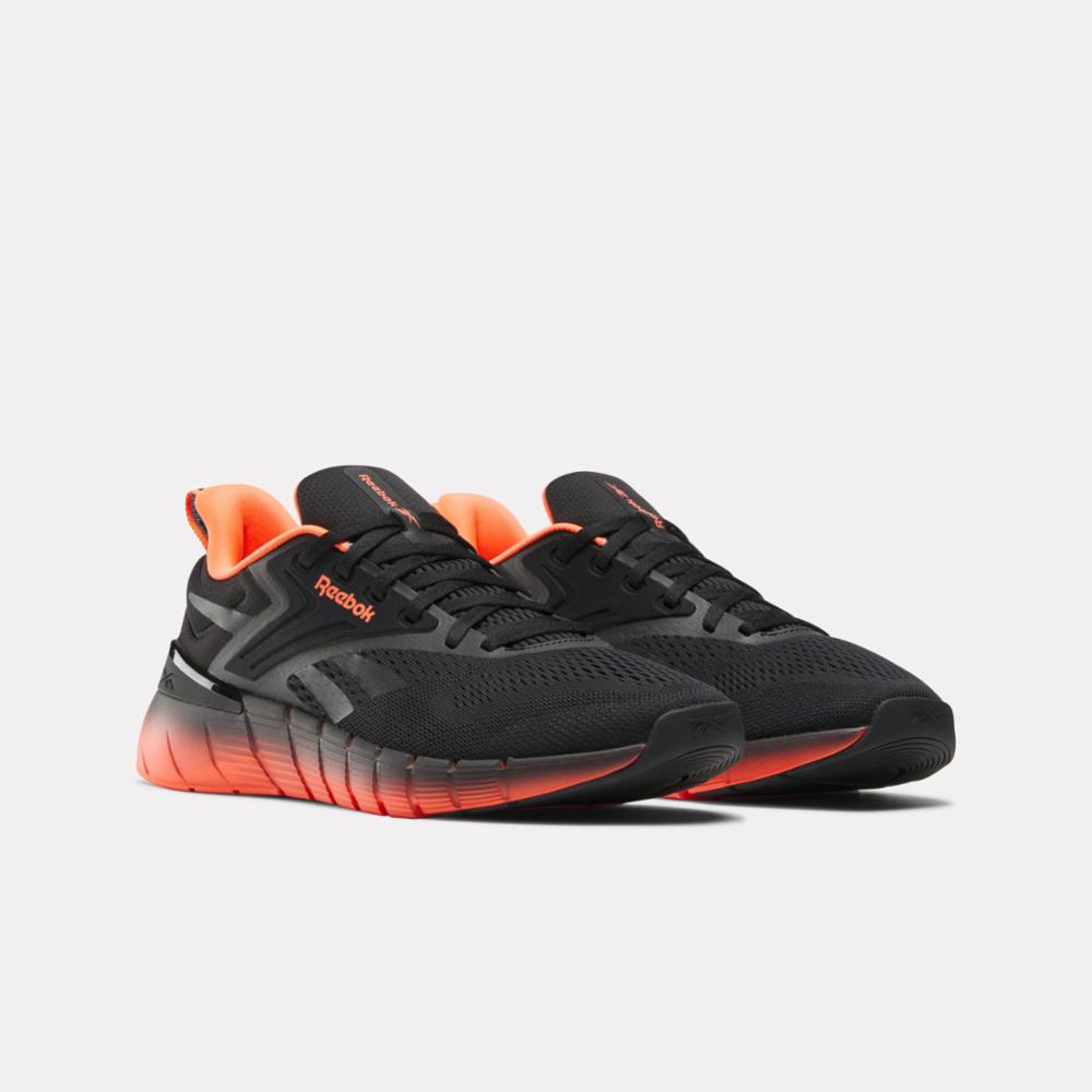 Pair of black running shoes with orange soles and interior.