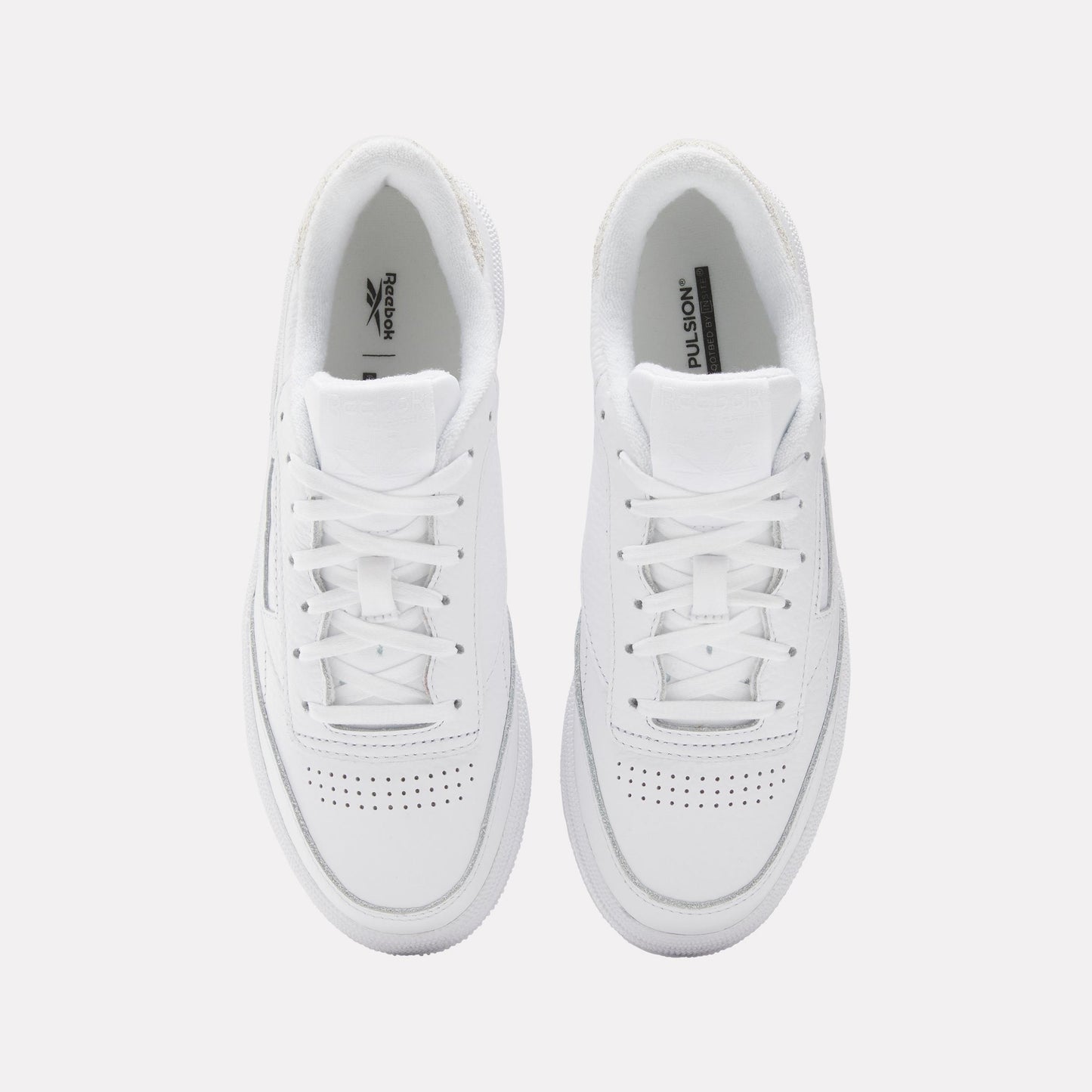 A pair of white leather sneakers with white laces and perforated toe box.