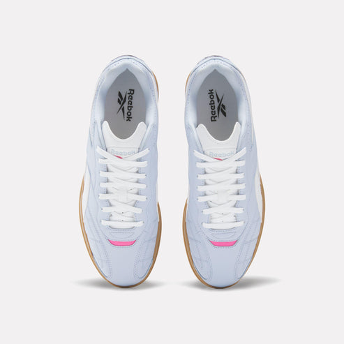 Overhead view of light blue sneakers with white laces and rubber soles.