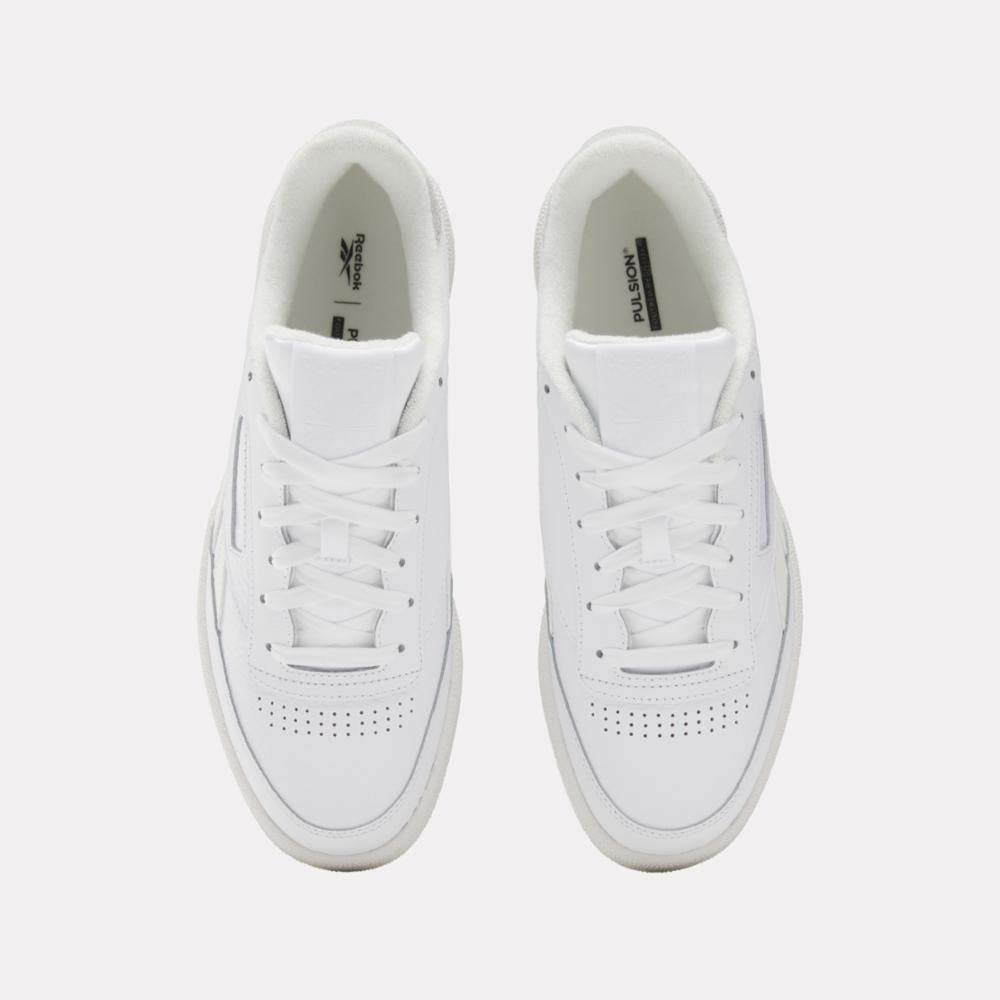 Overhead view of two white sneakers with white laces and perforated toeboxes.