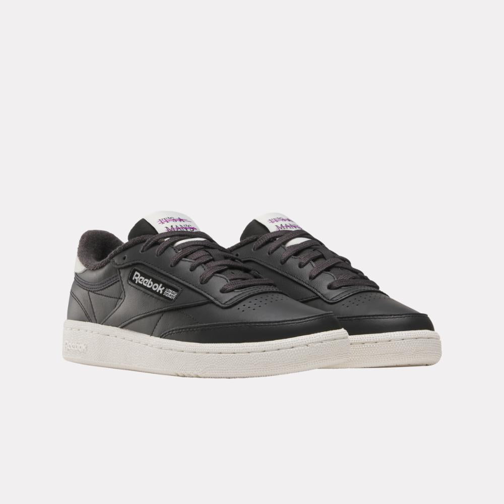 Low-top black leather sneakers with white soles, white heel accent, and branding on the side.