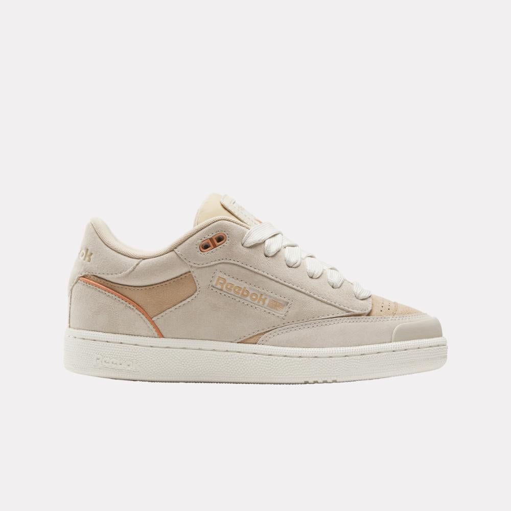 A low-rise beige sneaker with white laces and a white rubber sole. 'Reebok' is visible on the side.
