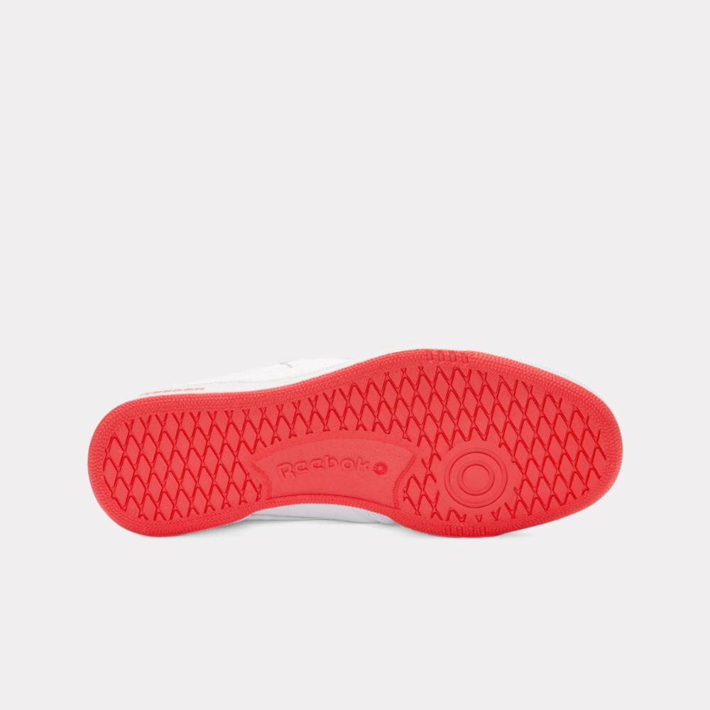 Red sole of a white sneaker with logo.