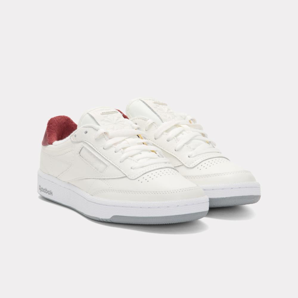Pair of low-top white sneakers with red heel.