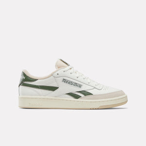 A low-top white sneaker with green stripes and a tan sole.