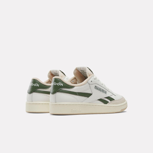 Low-cut white sneakers with dark green stripes on the side.