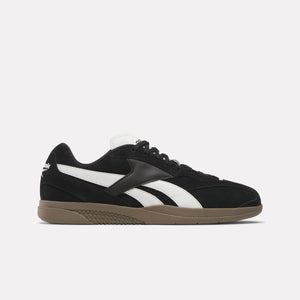 Black low-top sneaker with a white stripe and brown sole.