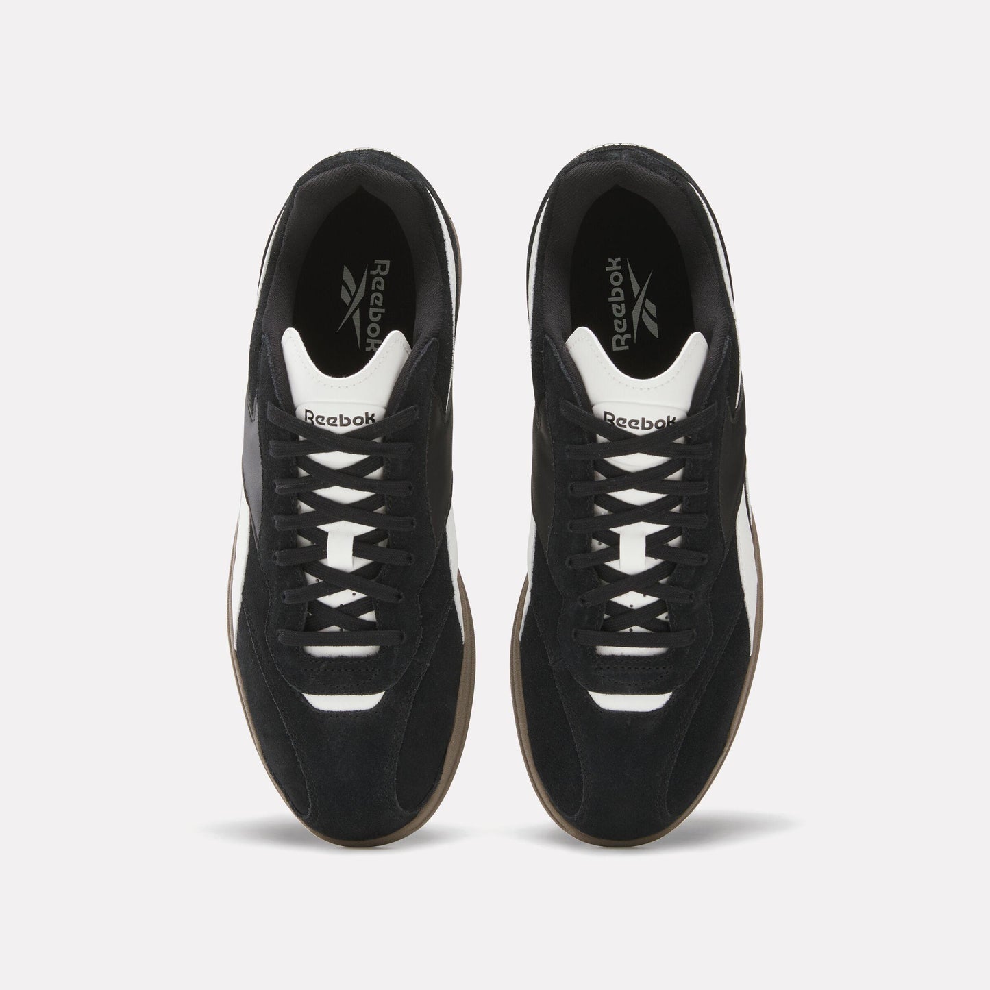 Overhead view of black and white sneakers with Reebok logo.