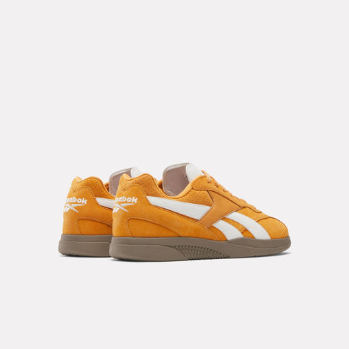 Pair of orange sneakers with white stripes and brown soles, shown from the back.