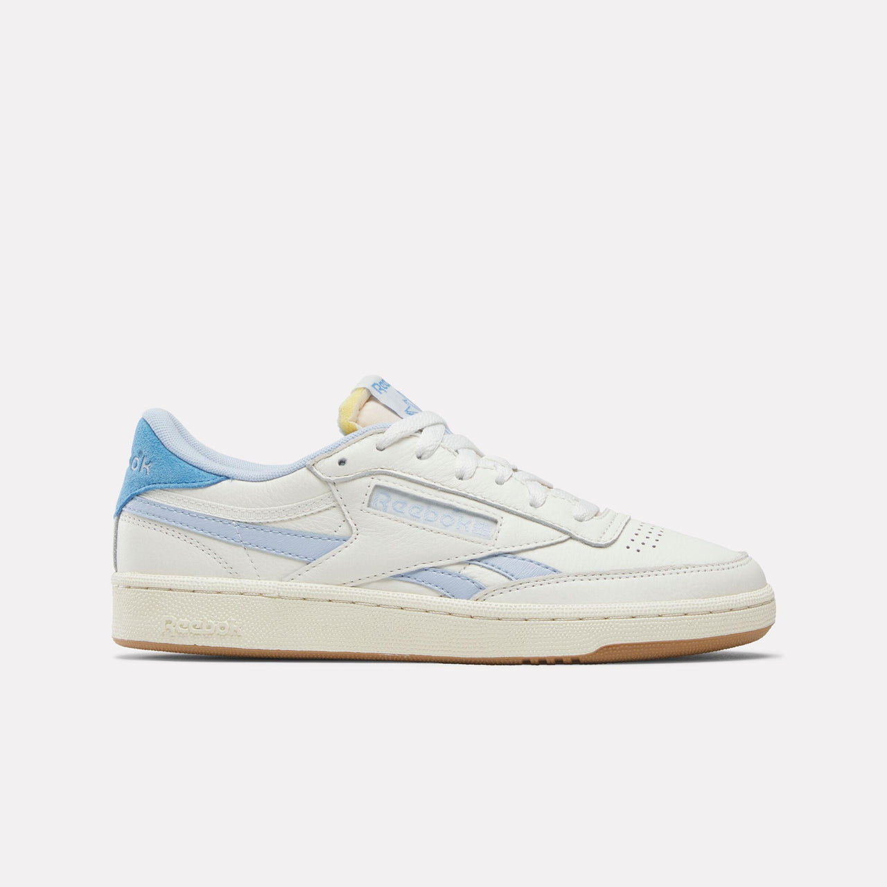 A low-top, off-white sneaker with blue accents, featuring a gum rubber sole.