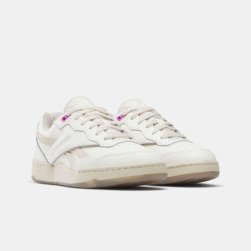 Off-white sneakers with lace-up closure and perforations.