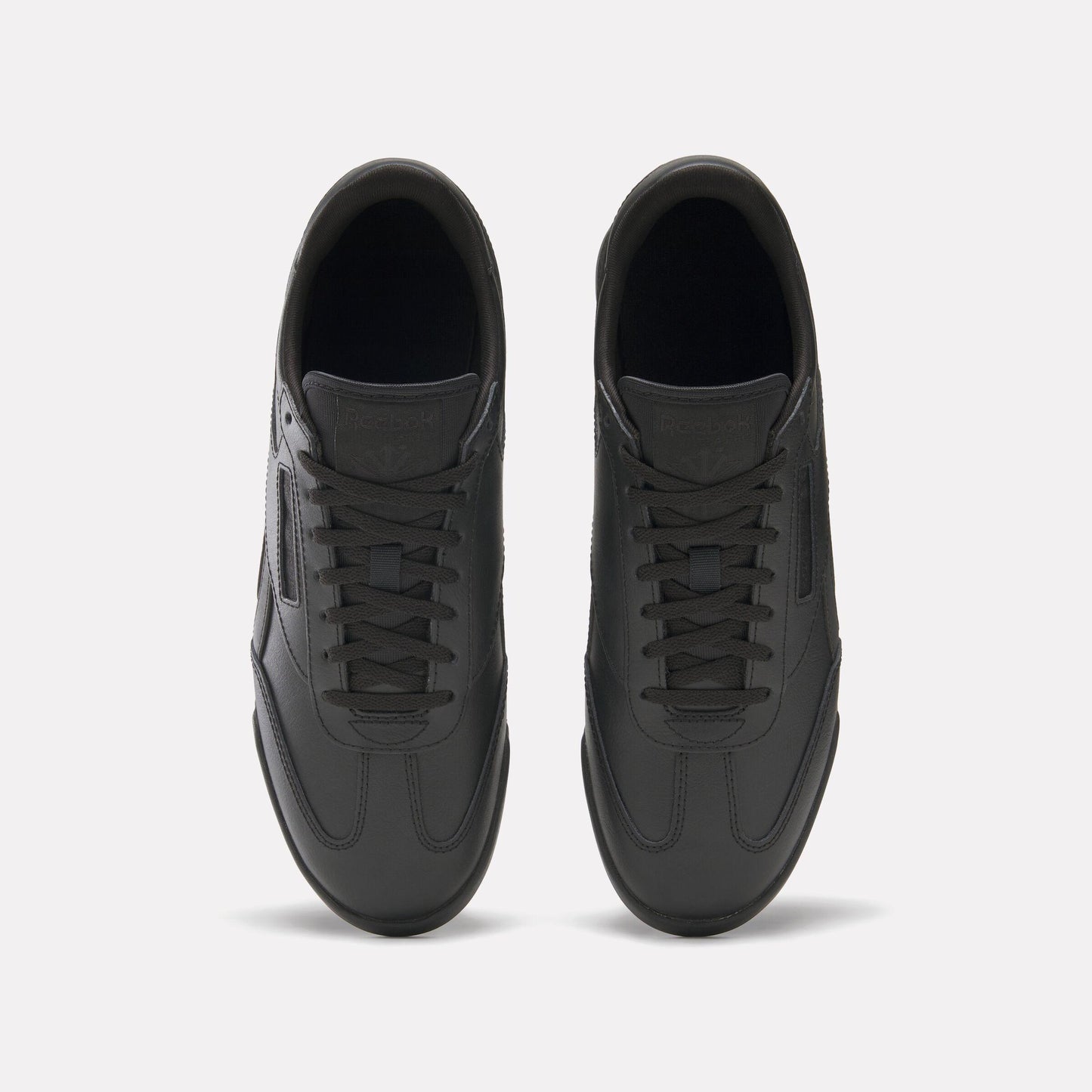 Top-down view of black leather sneakers with lace-up closure.