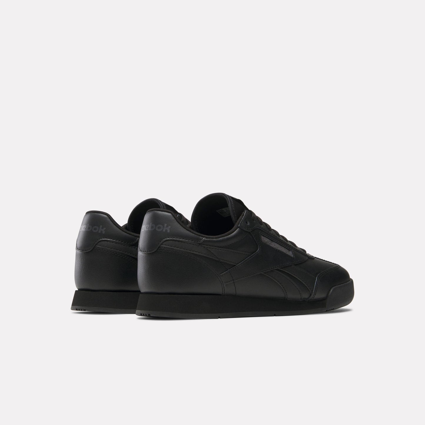 Low-profile black leather sneaker, side profile.