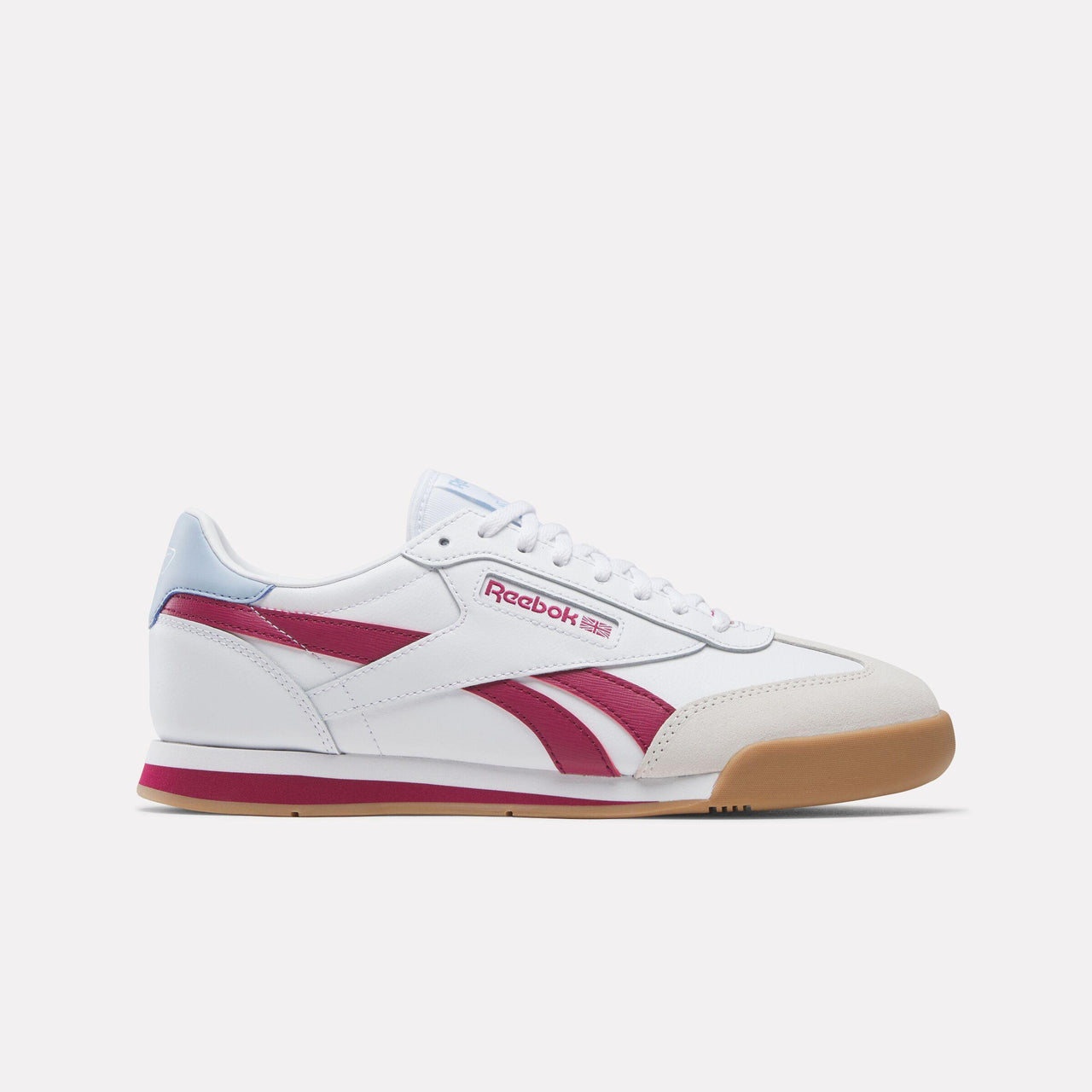 White sneaker with a light blue heel accent and pink stripes and sole; "Reebok" displayed on side.
