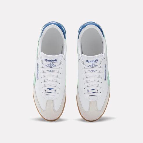 Top-down view of white sneakers with light green accents, blue trim, and gum soles.