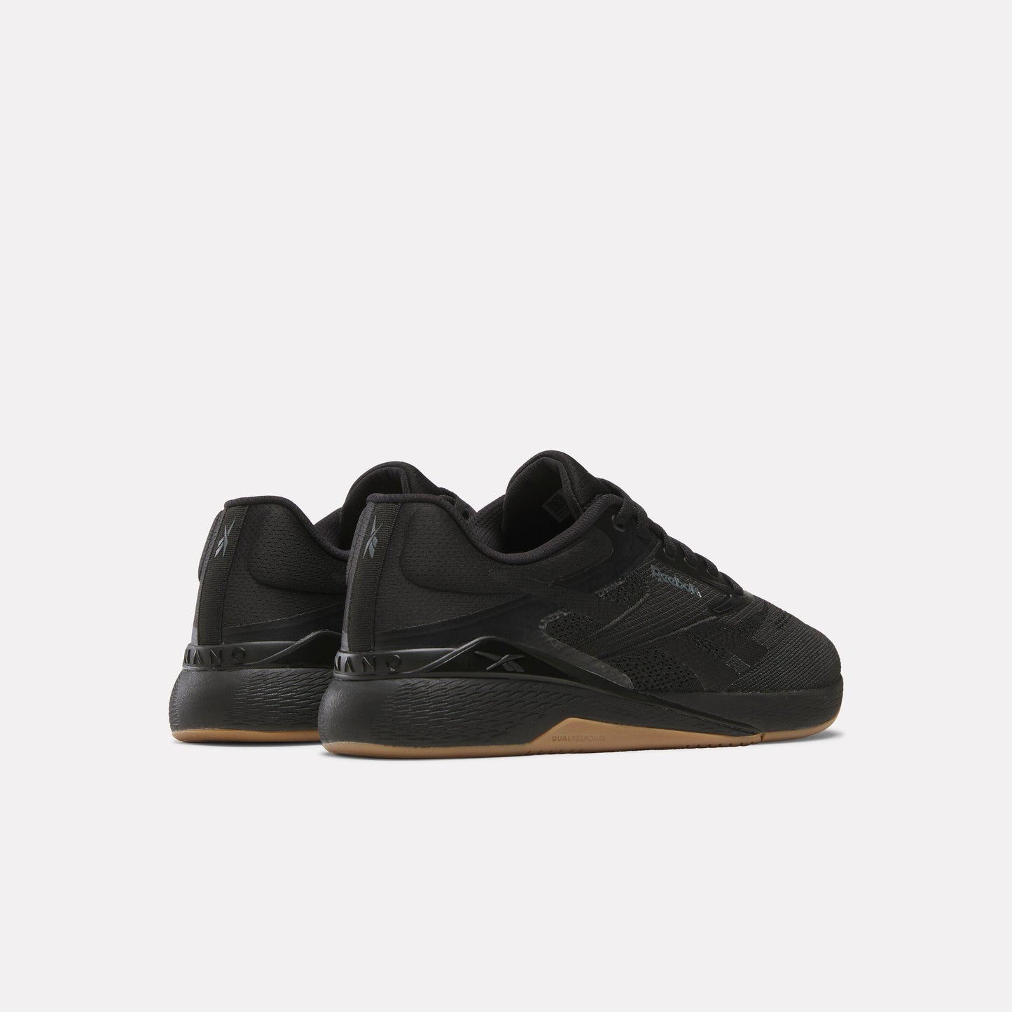 Pair of low-rise athletic shoes in solid black with a brown sole.