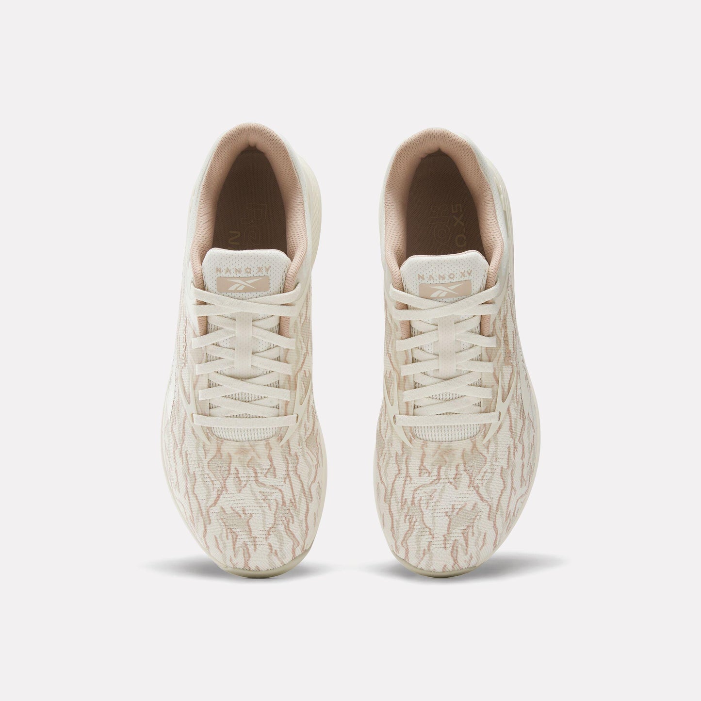 Top-down view of two off-white athletic shoes with laces.