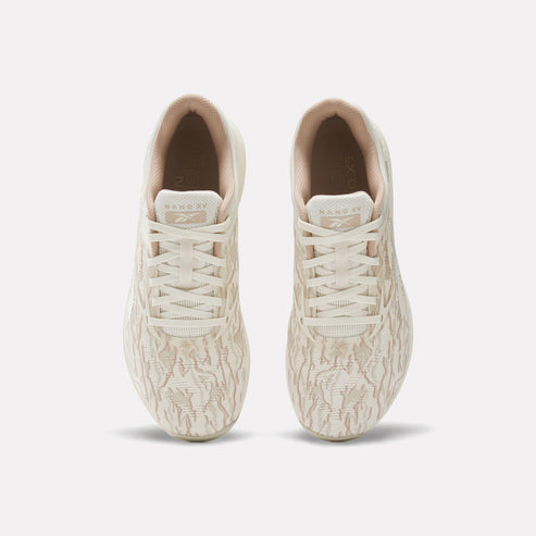 Top-down view of two off-white athletic shoes with laces.