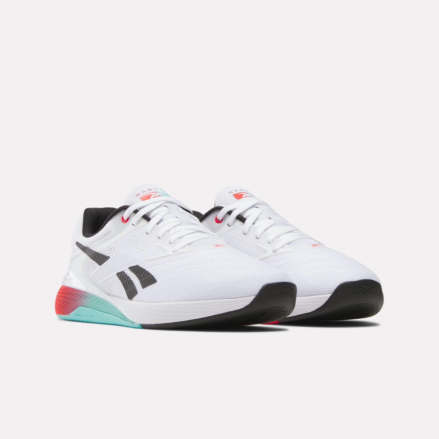 A pair of white running shoes with black soles and teal and red accents on the heel.