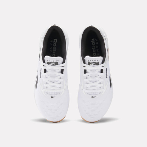Overhead view of two white athletic shoes with white laces and black interior lining. Text "Reebok Nano XV" is visible on the tongue of the shoe. 