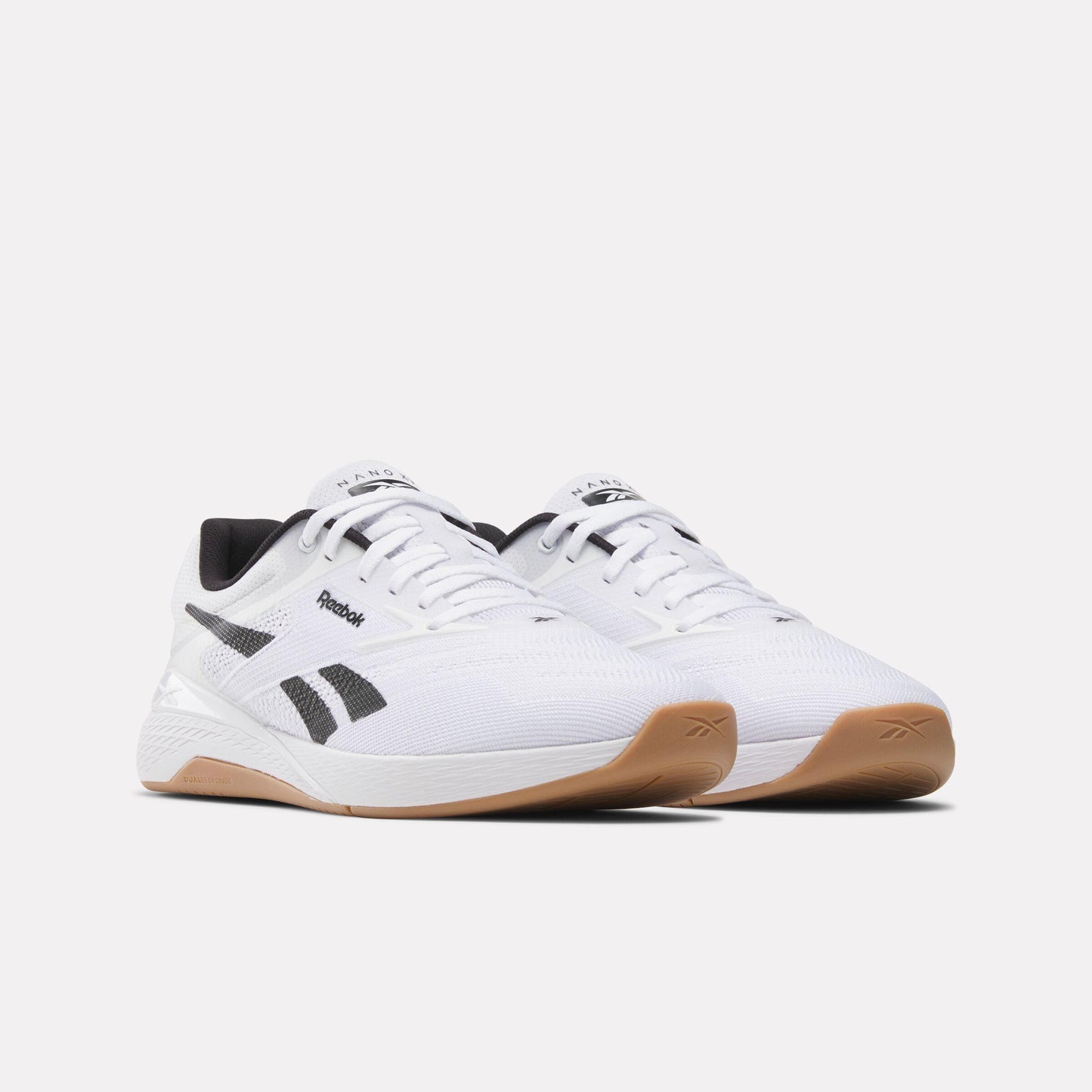 Pair of white athletic shoes with black accents and gum soles.
