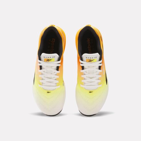 A pair of running shoes with white laces and a faded yellow-to-orange gradient.
