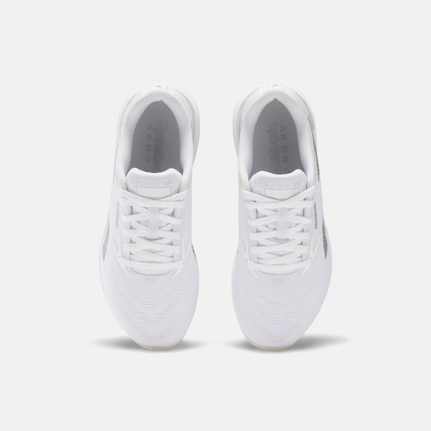 Pair of white athletic shoes, top view.