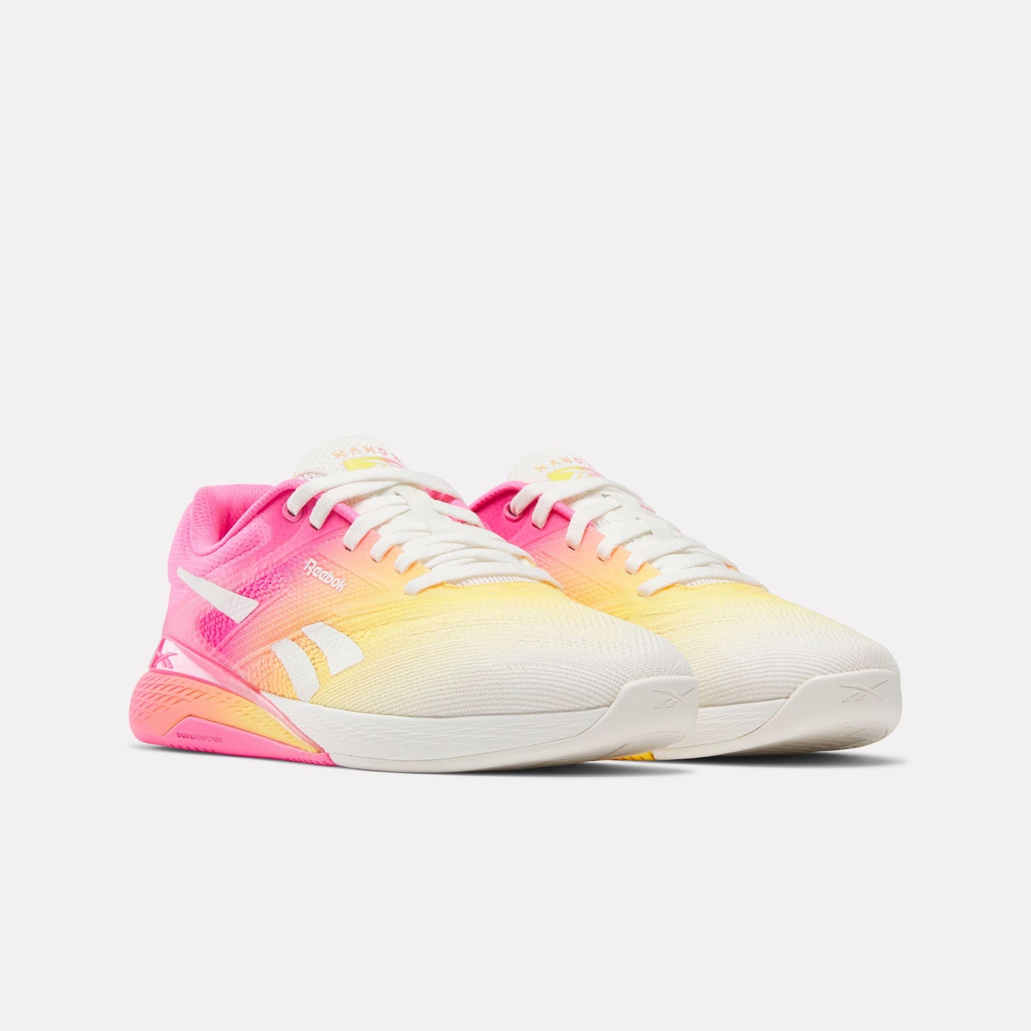 Pair of low-top white athletic shoes with pink and yellow ombre.