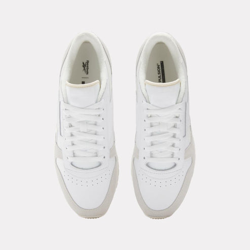 Overhead shot of two identical white sneakers with white laces.