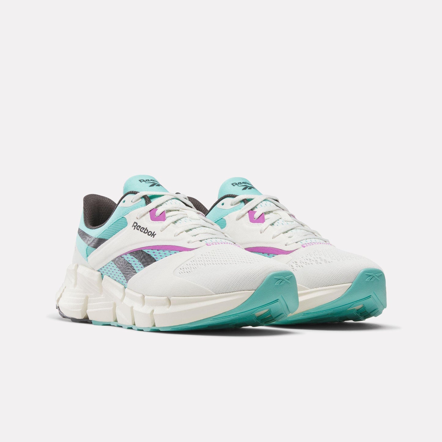 Pair of white running shoes with light blue and purple accents, featuring a zig-zag patterned sole.