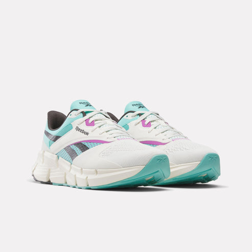 Pair of white running shoes with light blue and purple accents, featuring a zig-zag patterned sole.