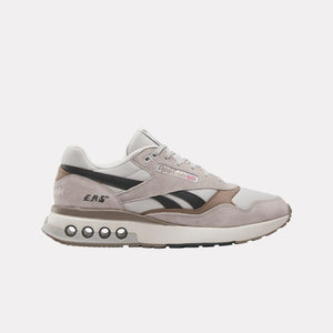 A low-top running shoe in light gray and black with visible 'ERS' and the Reebok logo.