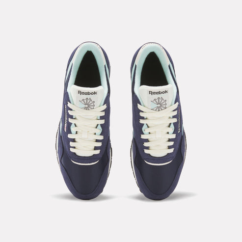 Overhead view of two navy Reebok Classics shoes, with cream laces, and pale green lining.