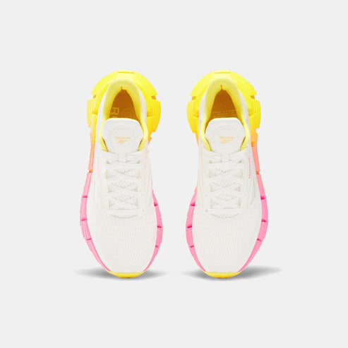 Top-down view of two white sneakers, each with yellow and pink accents.