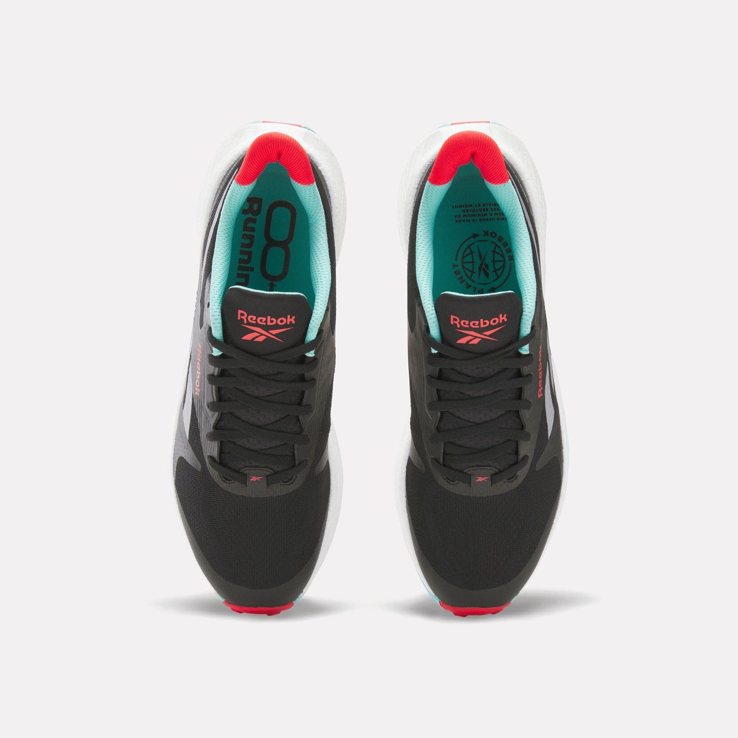 Overhead view of two athletic shoes. Both shoes have a black upper with black laces, a white midsole, and a red and white outsole. The shoe linings are teal, and "Reebok" is written on the tongue in red.