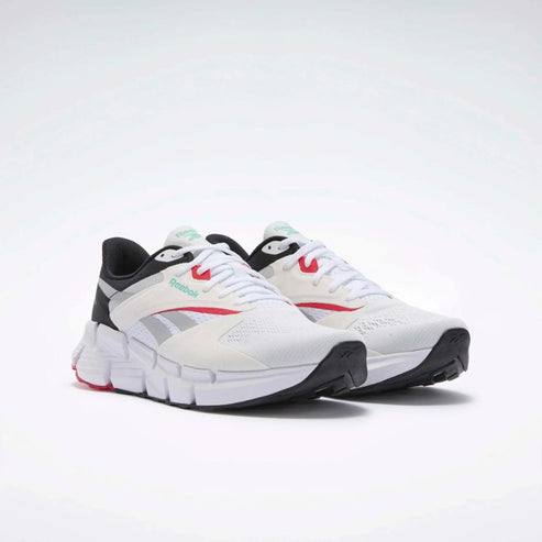 A pair of white athletic sneakers with black soles and red and gray accents.
